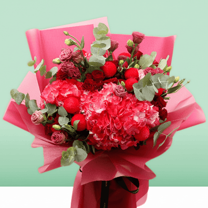 Pink hydrangea, red spray roses and ping pong chrysanthemums bouquet with eucalyptus in bright pink wrapping