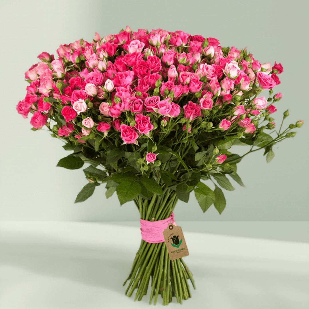 Large hand-tied bouquet of pink spray roses with fresh green foliage