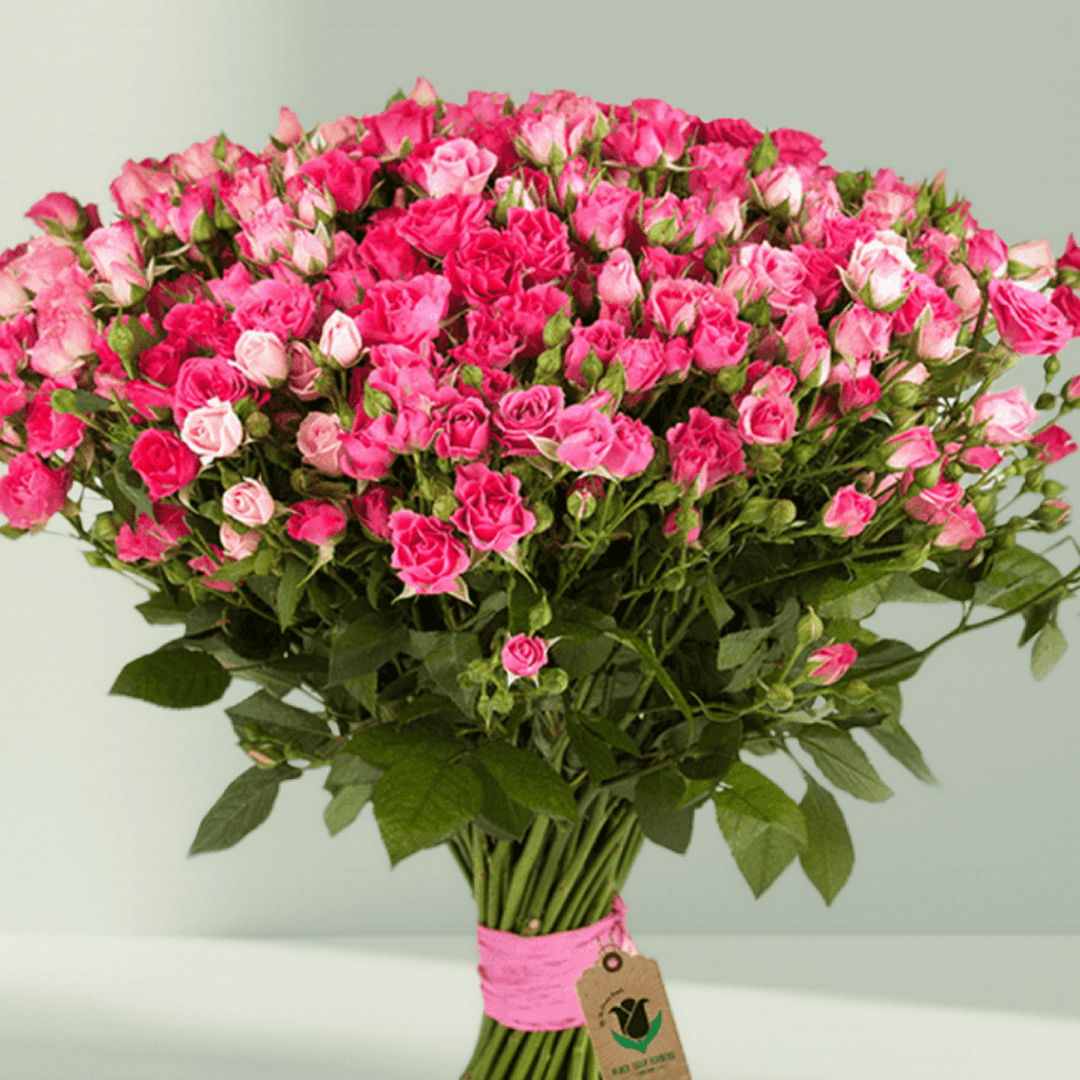Large hand-tied bouquet of pink spray roses with fresh green foliage