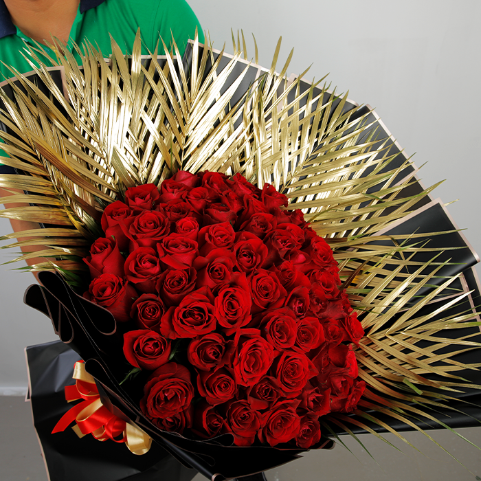 50 red roses with gold-toned palm leaves in black Korean-style wrapping