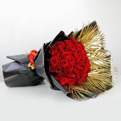 50 red roses with gold-toned palm leaves in black Korean-style wrapping