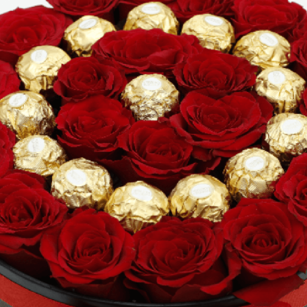 Red roses arranged with 16 Ferrero Rocher chocolates in a black round gift box