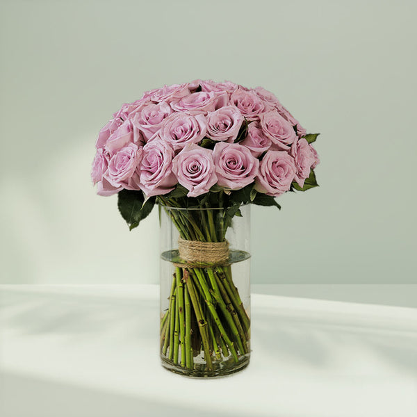 Bunch of purple roses arranged in a glass vase