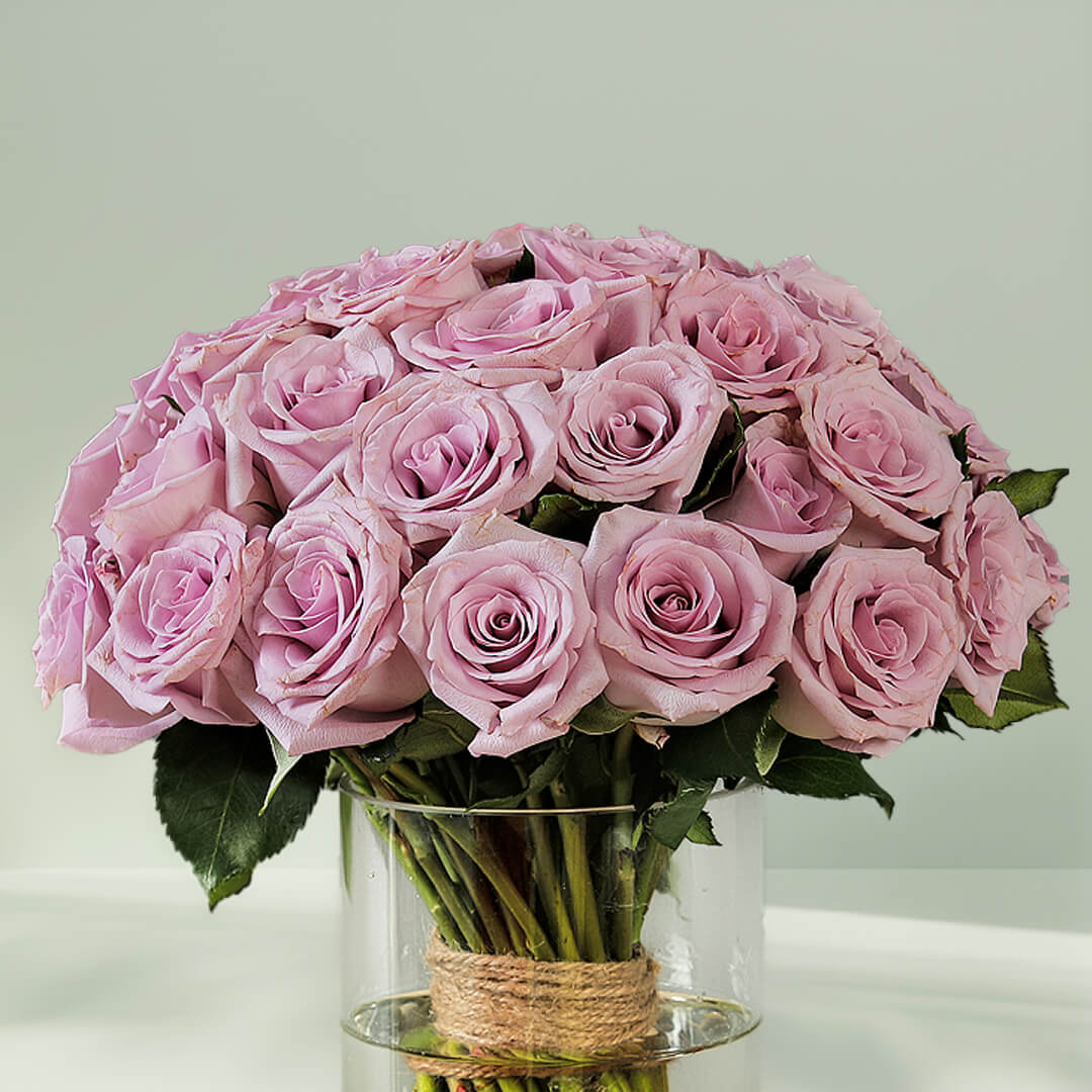 Bunch of purple roses arranged in a glass vase