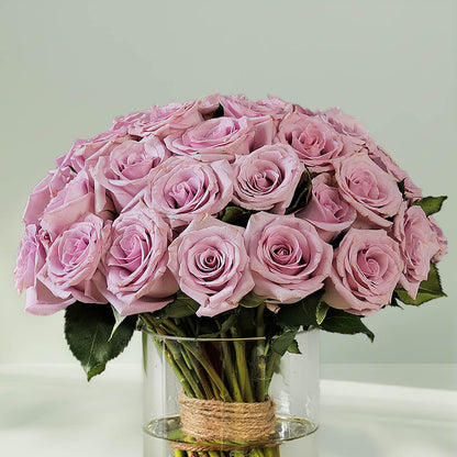 Bunch of purple roses arranged in a glass vase
