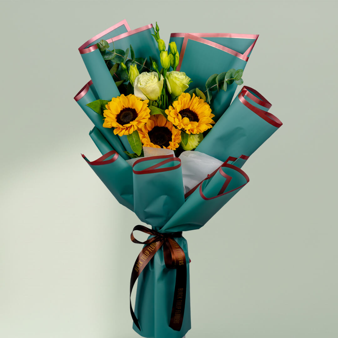 Sunflower bouquet with white roses, Eustoma and greenery wrapped in stylish teal floral paper.