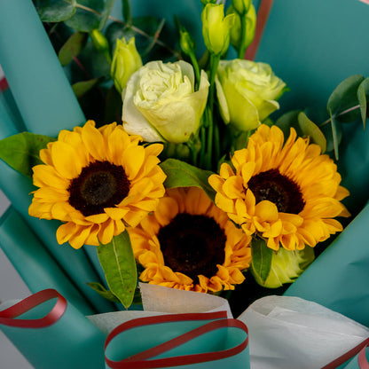 Sunflower bouquet with white roses, Eustoma and greenery wrapped in stylish teal floral paper.