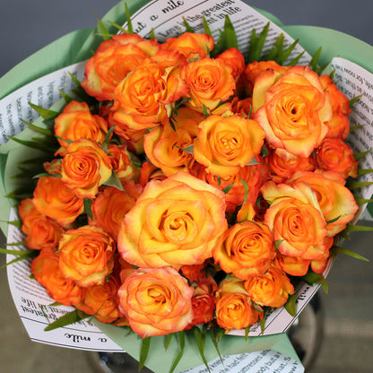 Bouquet of 40 fresh orange roses arranged in green and newspaper-style Korean wrapping sheets.