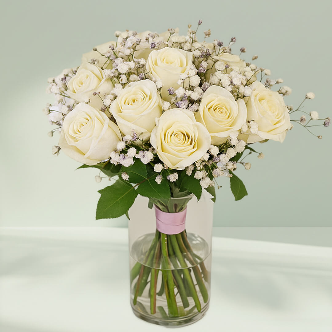 20 white roses with gypsophila arranged in a cylindrical glass vase.