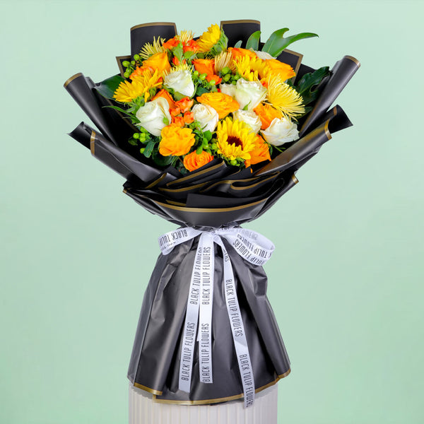 Bouquet with sunflowers, roses, spray roses, disbuds, hypericum, and green fillers in black wrapping