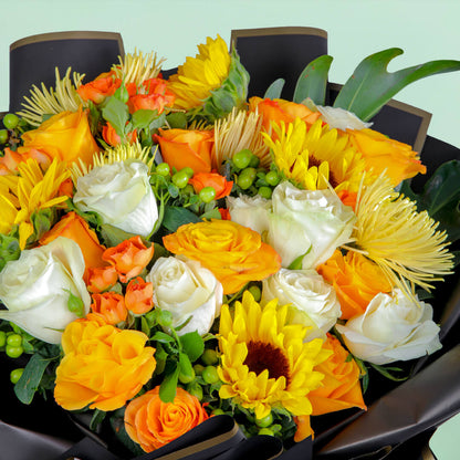 Bouquet with sunflowers, roses, spray roses, disbuds, hypericum, and green fillers in black wrapping