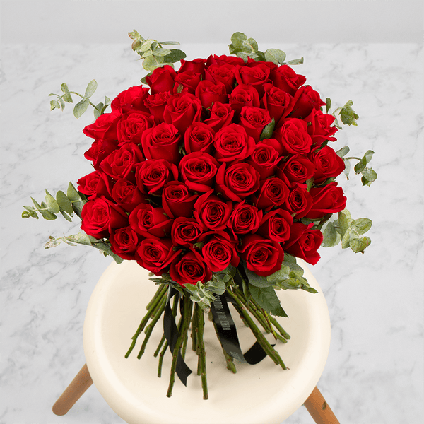 Hand-tied bouquet of 50 red Roses with fresh Eucalyptus foliage.