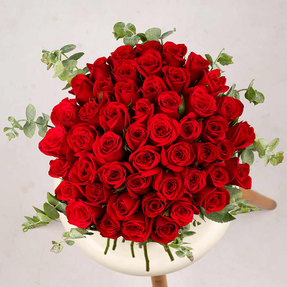 Hand-tied bouquet of 50 red Roses with fresh Eucalyptus foliage.