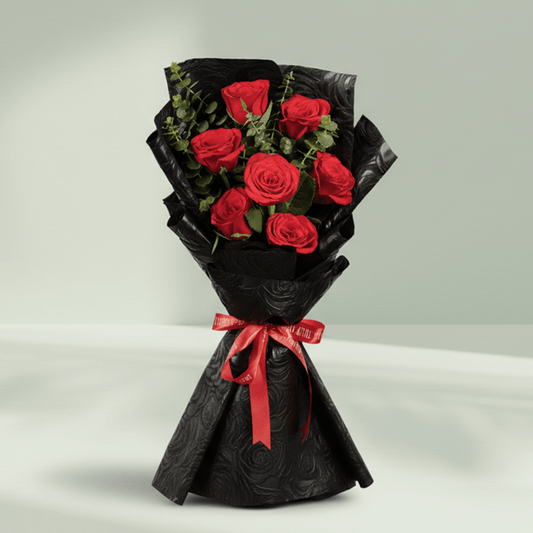7 red roses bouquet with eucalyptus in black wrapping