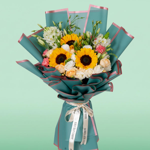 Assorted sunflower, rose, Eustoma and carnation bouquet in teal Korean wrapping