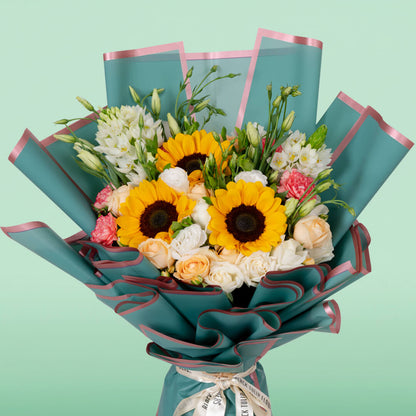 Assorted sunflower, rose, Eustoma and carnation bouquet in teal Korean wrapping