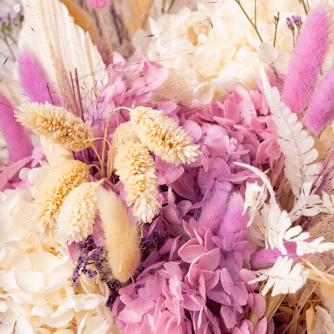 Arrangement featuring assorted dried and preserved flowers in white round box.