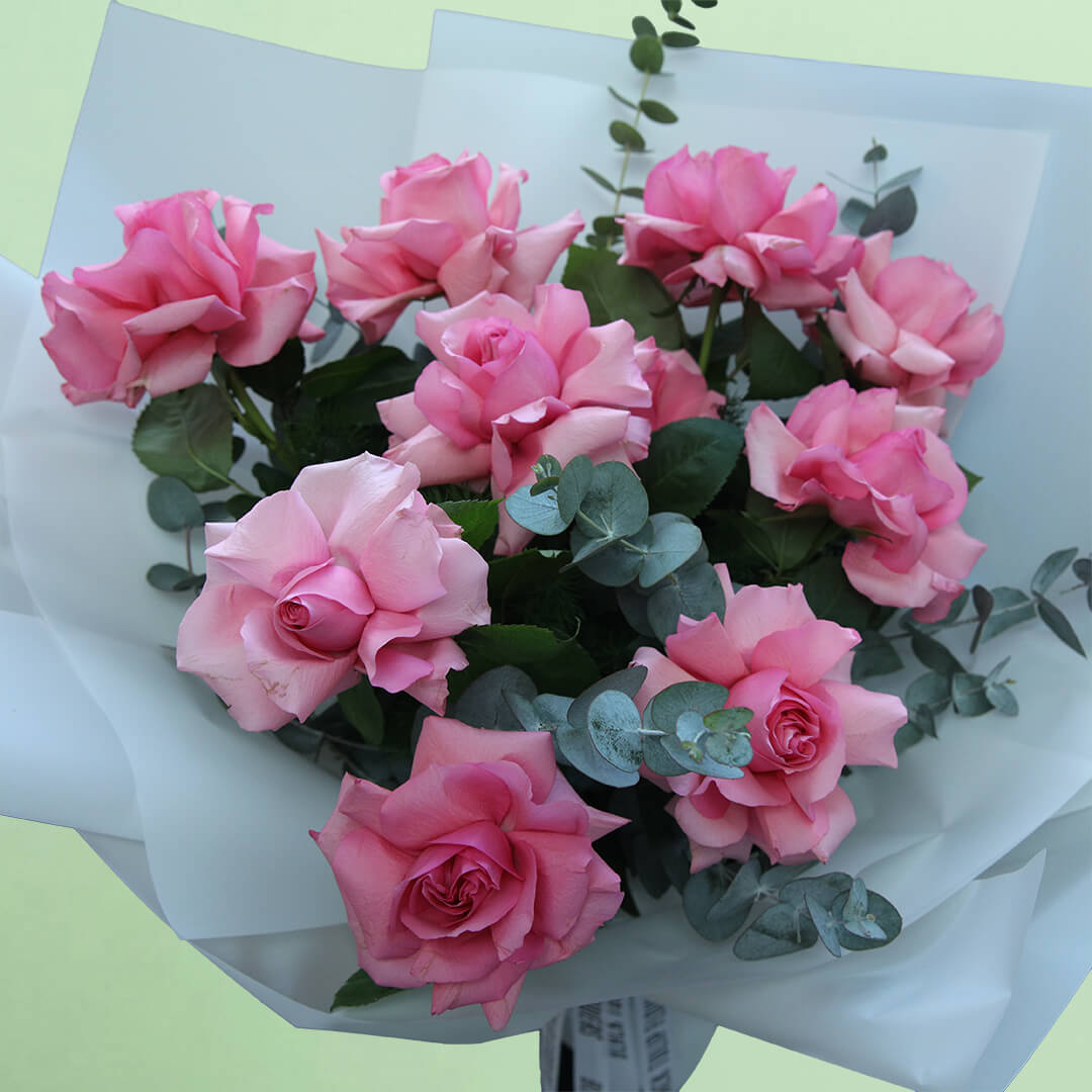 A beautiful bouquet of fresh pink roses, elegantly arranged with delicate foliage and wrapped in soft non-woven paper. The graceful pink colour makes it a thoughtful gift for birthdays, anniversaries, congratulations or heartfelt surprises.