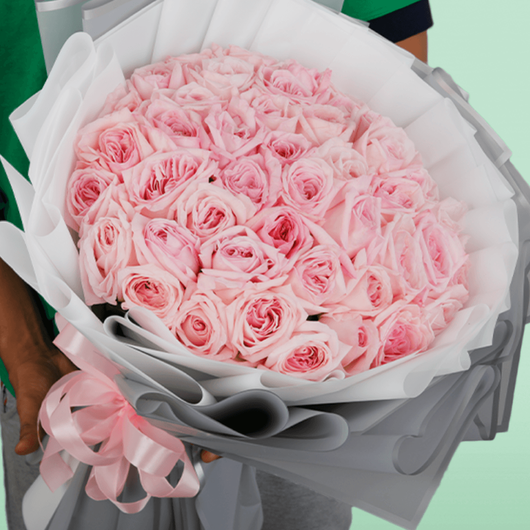 Large bouquet of 50 light pink roses in layered grey and white non-woven wrapping
