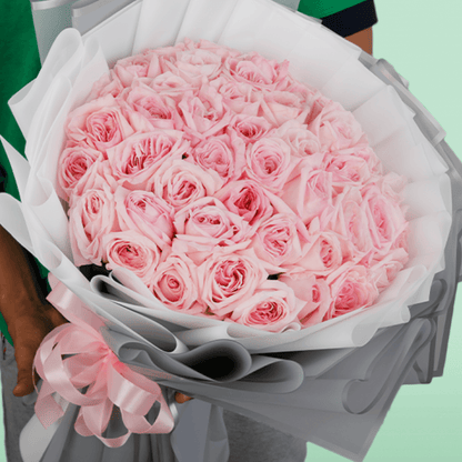 Large bouquet of 50 light pink roses in layered grey and white non-woven wrapping
