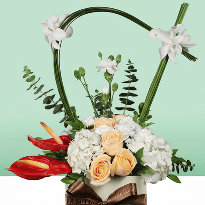 A small white square box of peach roses, white hydrangea, Eustoma, snapdragons, and steel grass.
