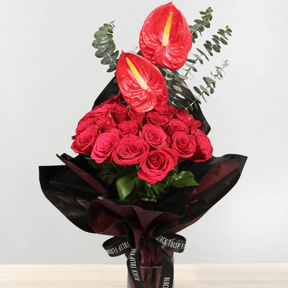 Red roses and anthuriums with eucalyptus greenery wrapped in black Korean-style flower wrapping sheets