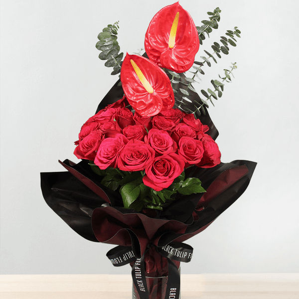 Red roses and anthuriums with eucalyptus greenery wrapped in black Korean-style flower wrapping sheets