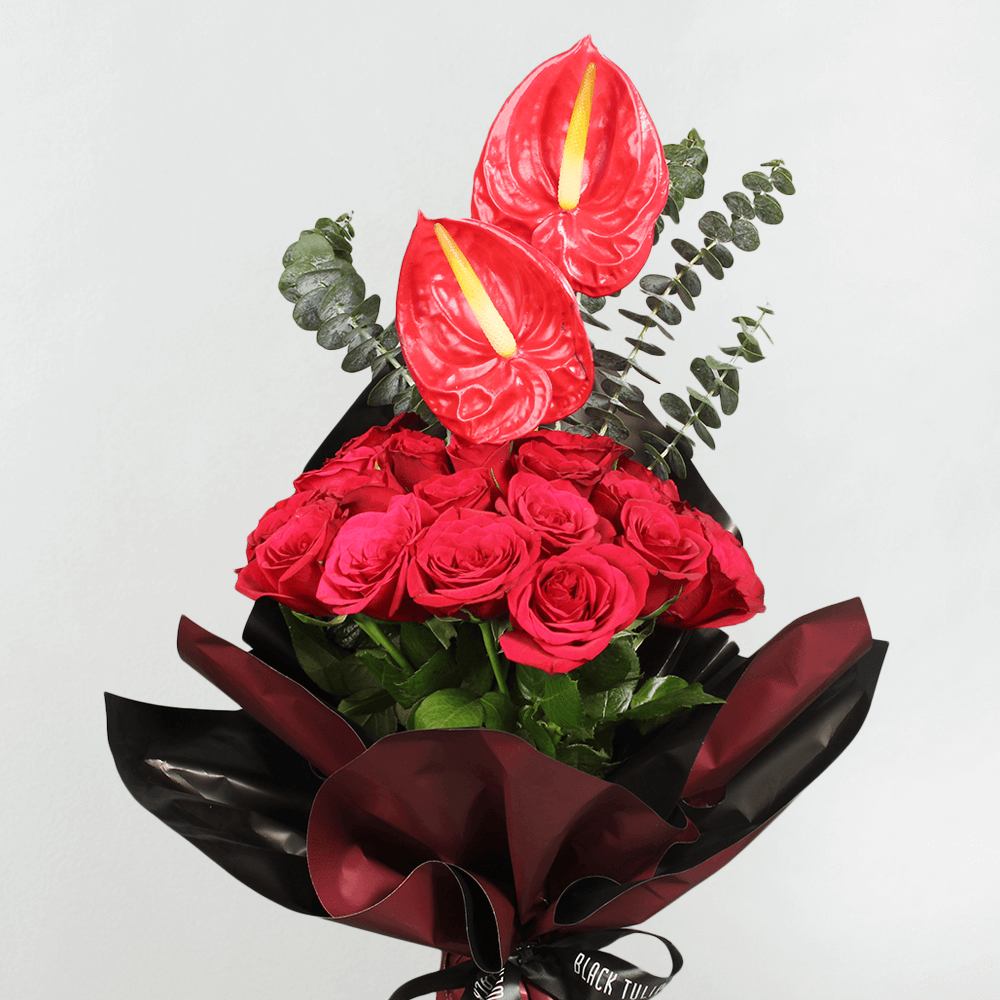 Red roses and anthuriums with eucalyptus greenery wrapped in black Korean-style flower wrapping sheets