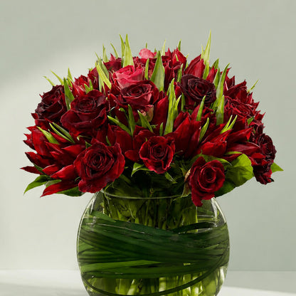 Lavish Red Tulip bouquet with red tulips and roses in glass fishbowl vase