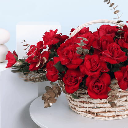 Basket arrangement of 30 red roses with Eucalyptus and decorative foliage.