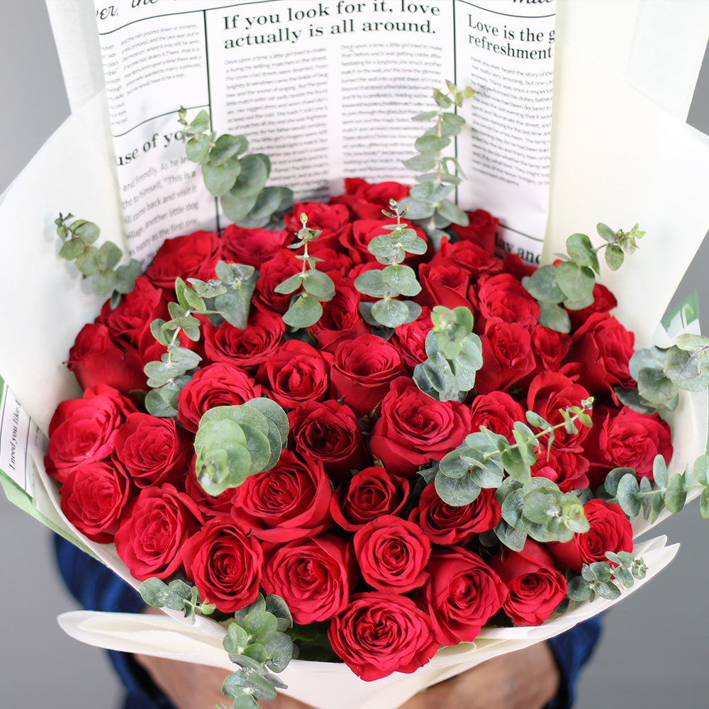 Premium bouquet of 40 red roses with fresh greenery wrapped in white non-woven paper
