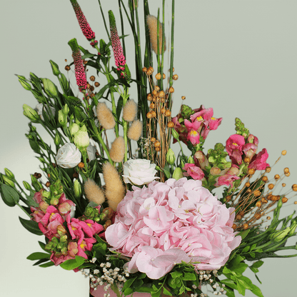 A round flower box with pink hydrangea, Eustoma, snapdragons, veronica and bunny tails.
