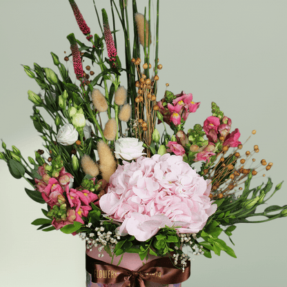 A round flower box with pink hydrangea, Eustoma, snapdragons, veronica and bunny tails.
