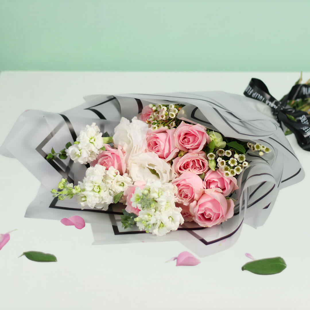 Pink Roses, white Eustoma, Snapdragons and Wax Flowers wrapped in white Korean-style flower sheets.