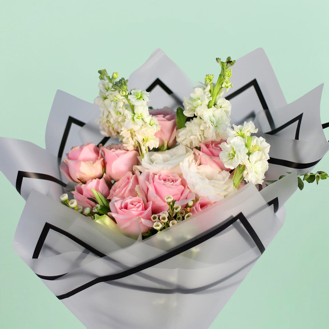 Pink Roses, white Eustoma, Snapdragons and Wax Flowers wrapped in white Korean-style flower sheets.