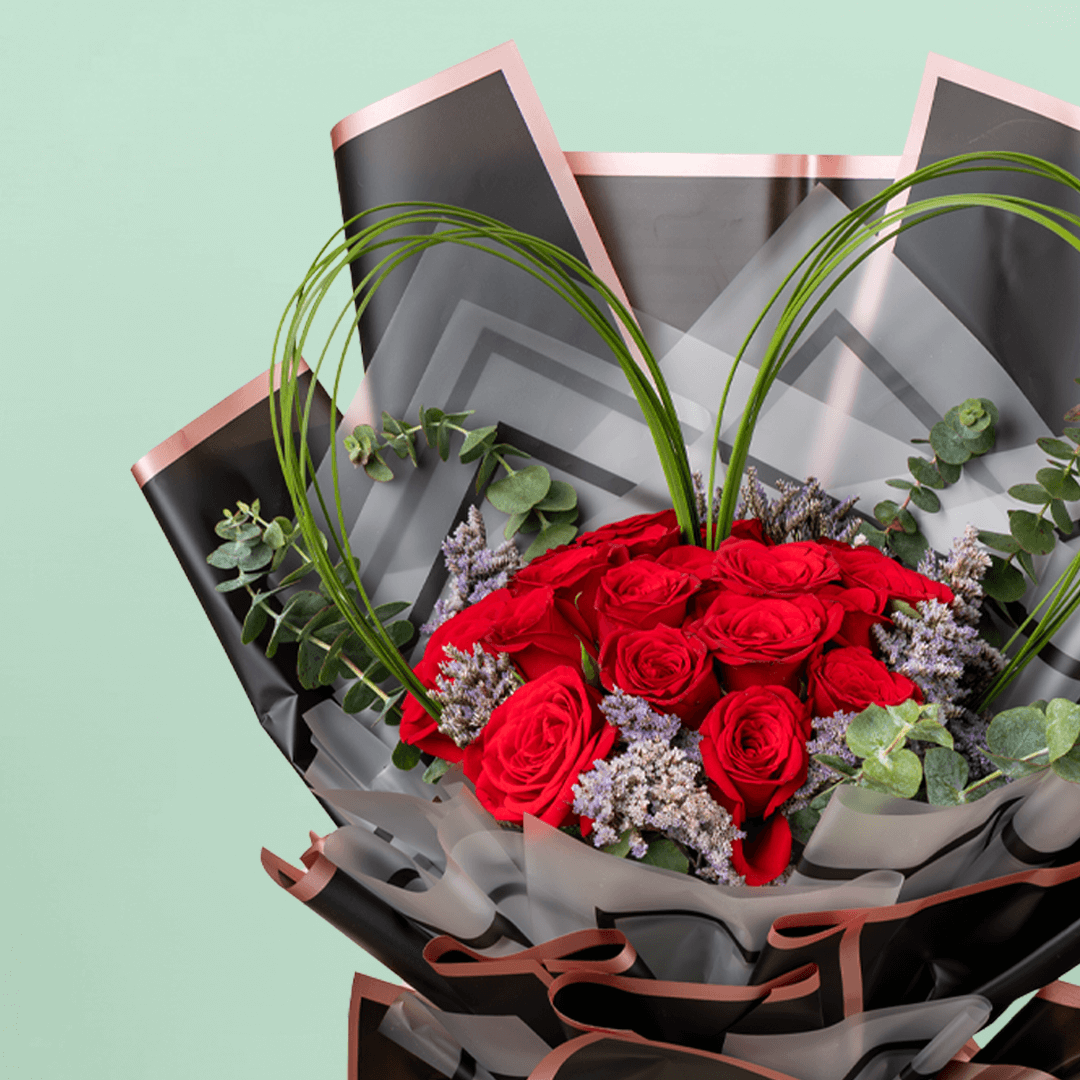 Bouquet of 25 red roses with steel grass, Limonium, and eucalyptus in black wrapping