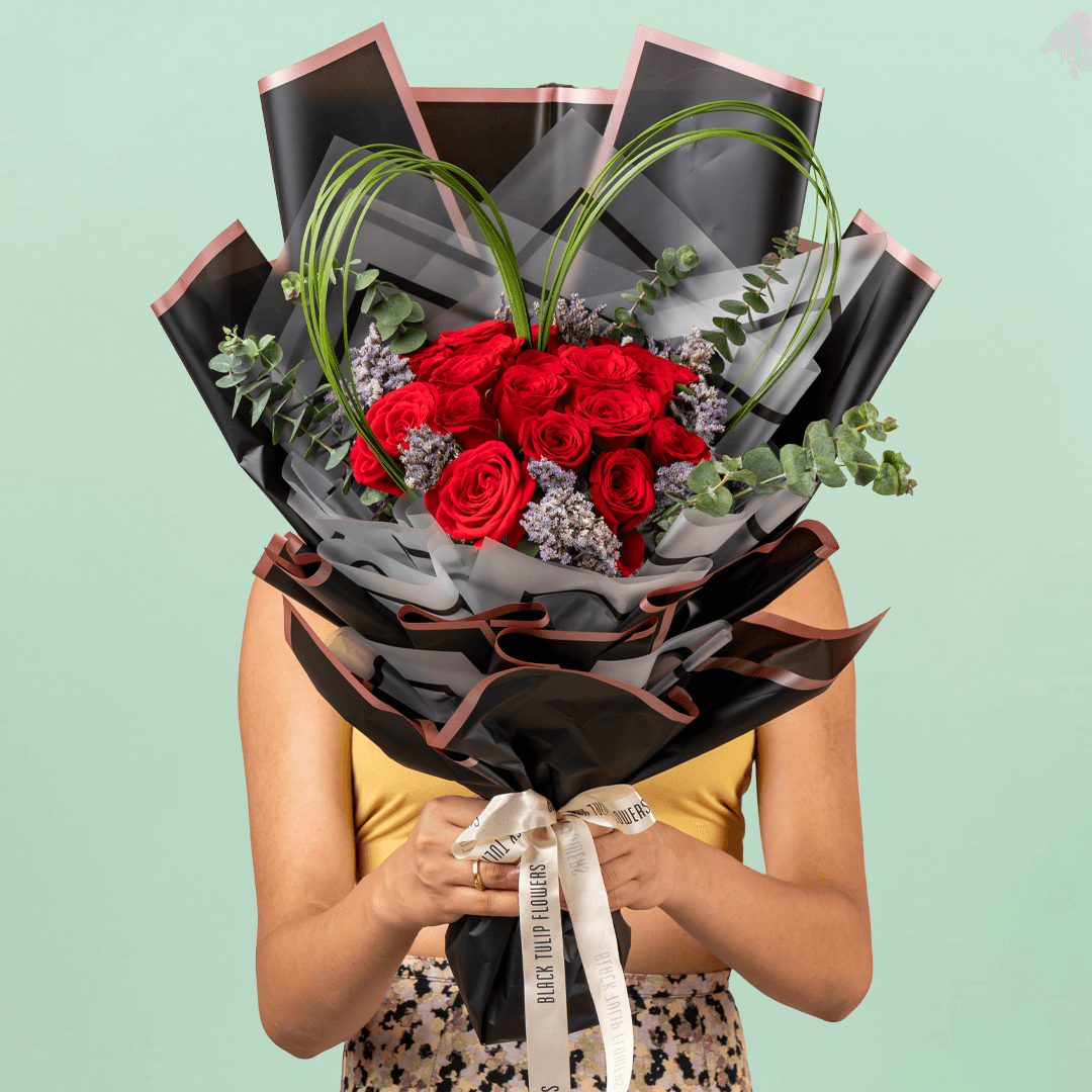 Bouquet of 25 red roses with steel grass, Limonium, and eucalyptus in black wrapping