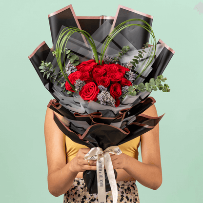 Bouquet of 25 red roses with steel grass, Limonium, and eucalyptus in black wrapping