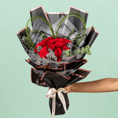Bouquet of 25 red roses with steel grass, Limonium, and eucalyptus in black wrapping