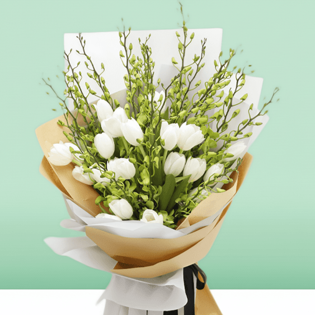 White tulips and orchid stems arranged with greenery in white and natural-toned wrapping

