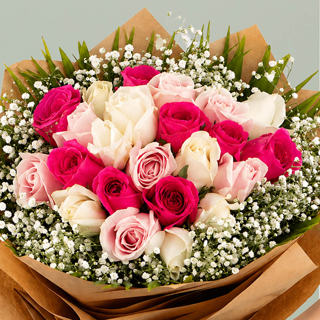 Deep pink, blush and white roses with baby’s breath wrapped in layered brown non-woven paper
