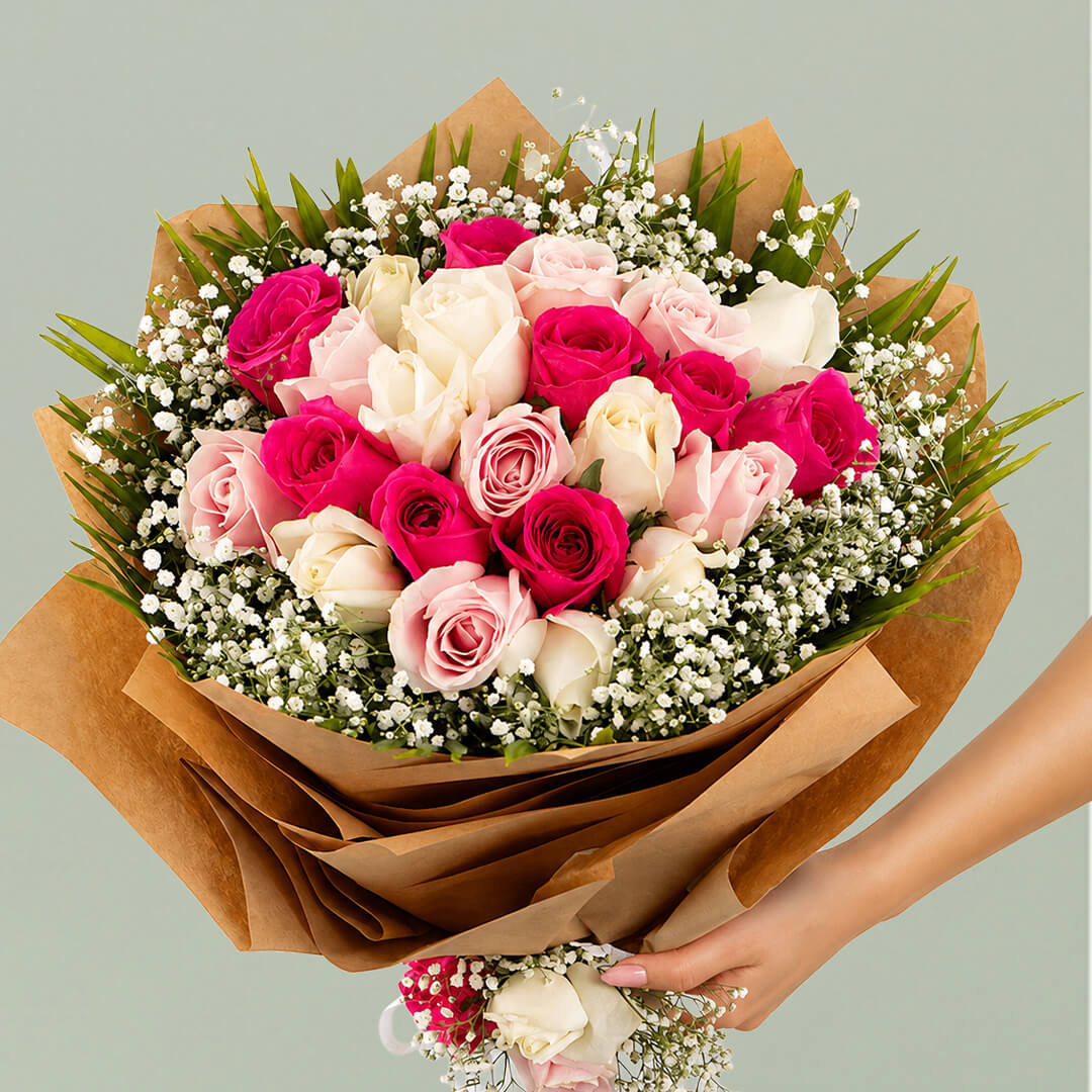 Deep pink, blush and white roses with baby’s breath wrapped in layered brown non-woven paper
