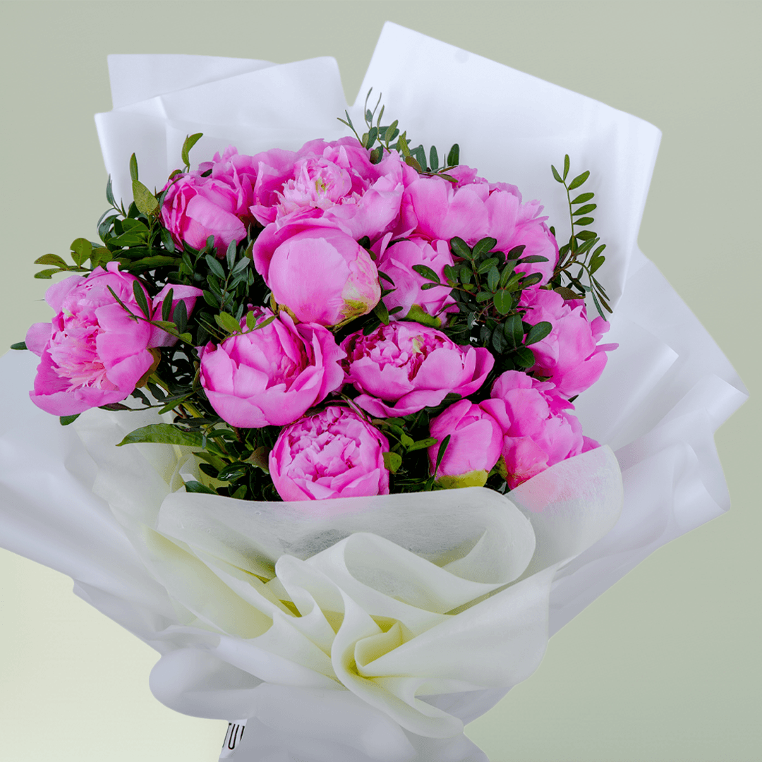 Pink peonies with greenery wrapped in elegant white.