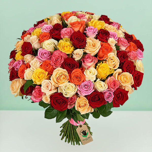 100 mixed roses bouquet in red, pink, yellow, peach, orange and cream tones, arranged in a full hand-tied style.