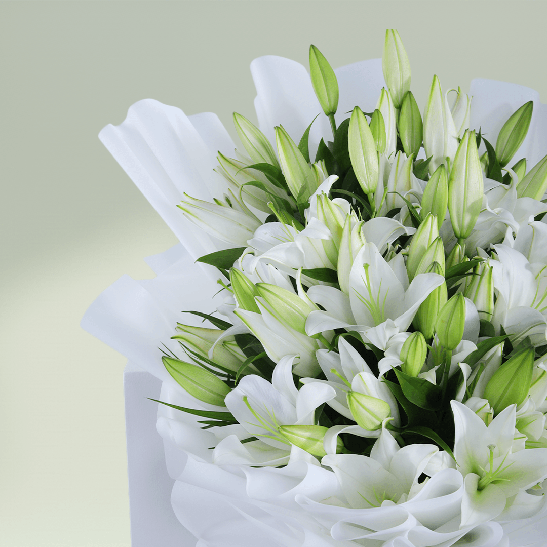 Bouquet of 10 fresh white Lilies with green foliage wrapped in white non-woven paper.