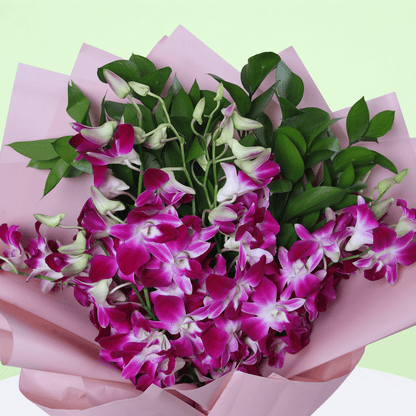 10 purple dendrobium orchids bouquet with greenery in pink wrapping and black ribbon