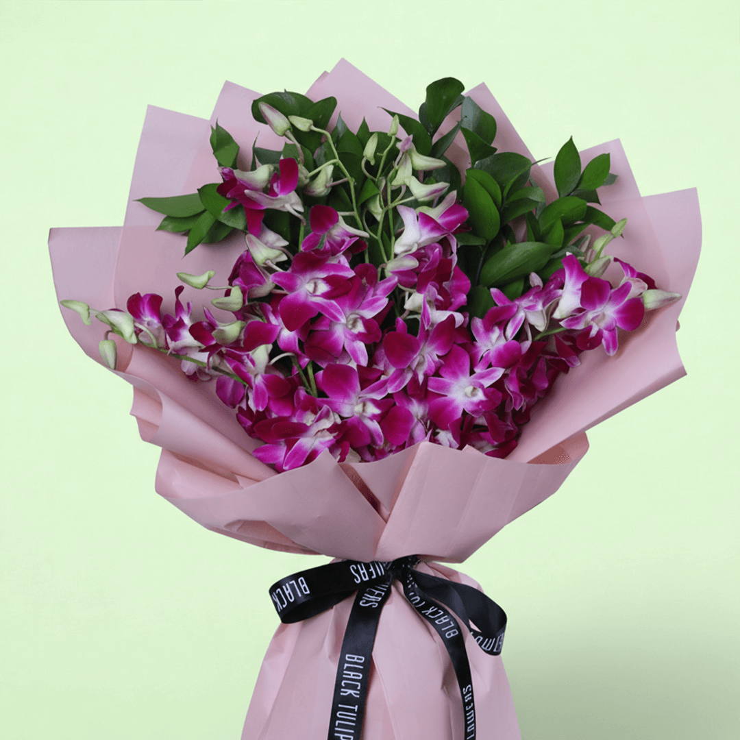 10 purple dendrobium orchids bouquet with greenery in pink wrapping and black ribbon