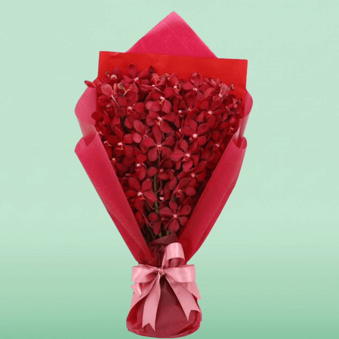 Red orchid stems arranged in layered red non-woven wrapping with a pink ribbon
