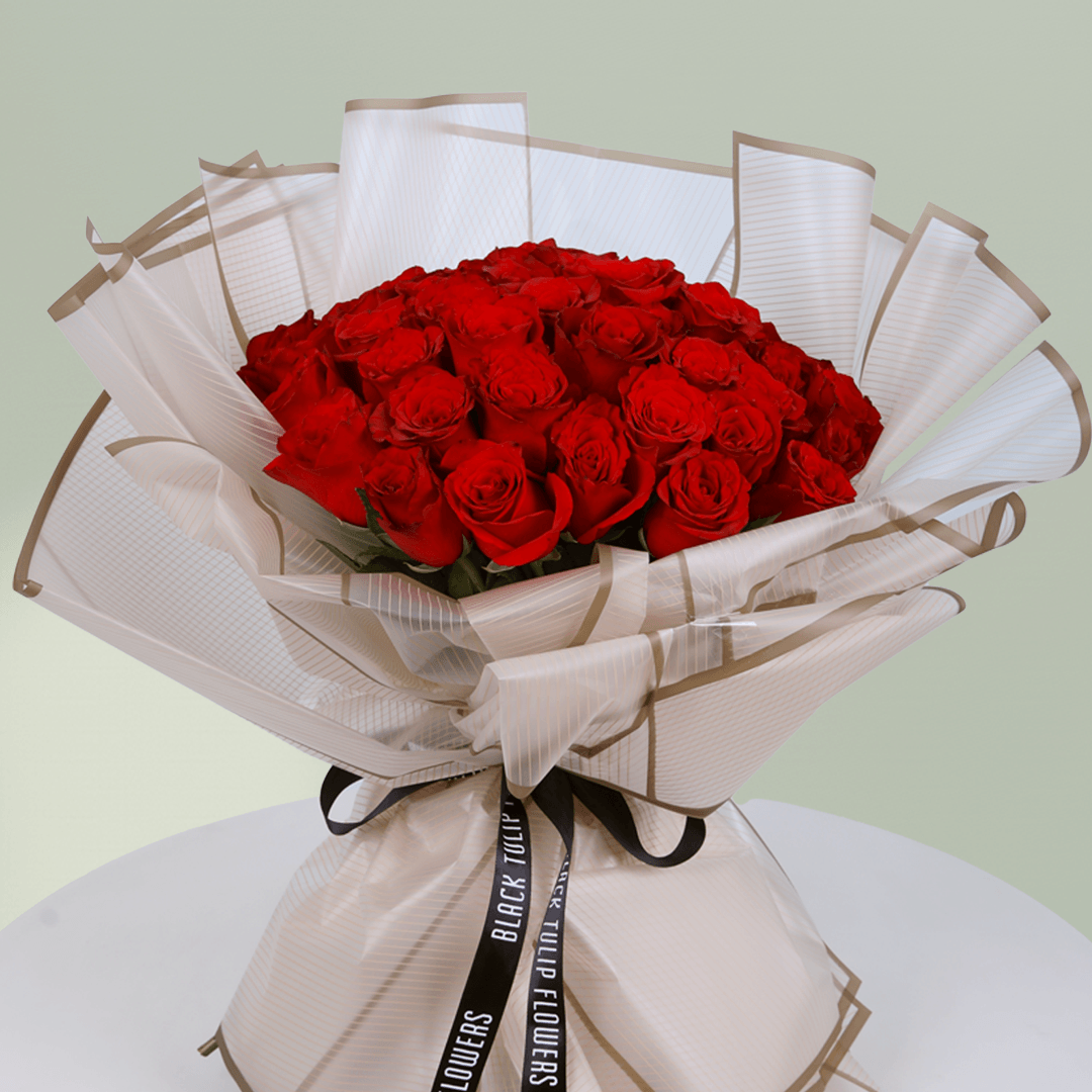 Bouquet of 35 red roses wrapped in elegant beige paper tied with black ribbon.