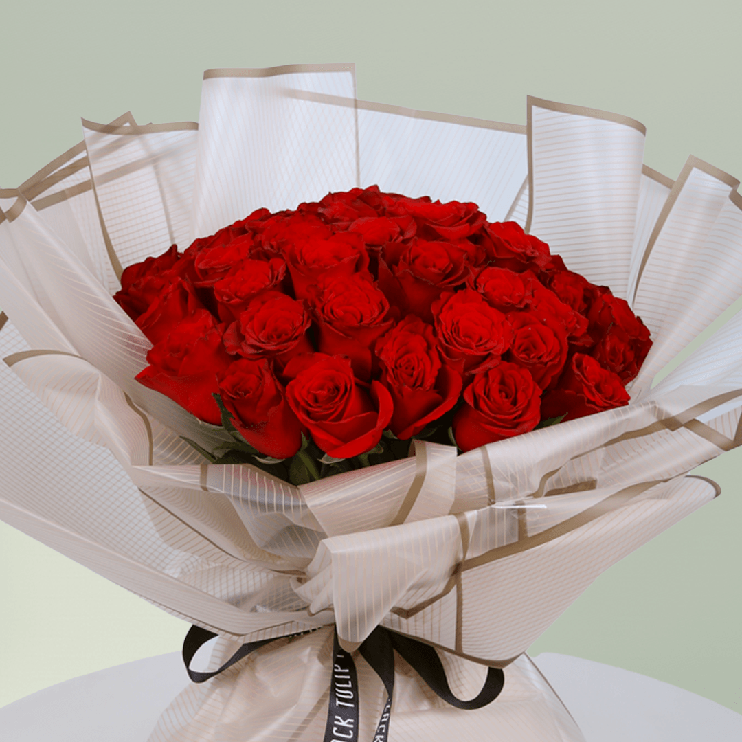 Bouquet of 35 red roses wrapped in elegant beige paper tied with black ribbon.